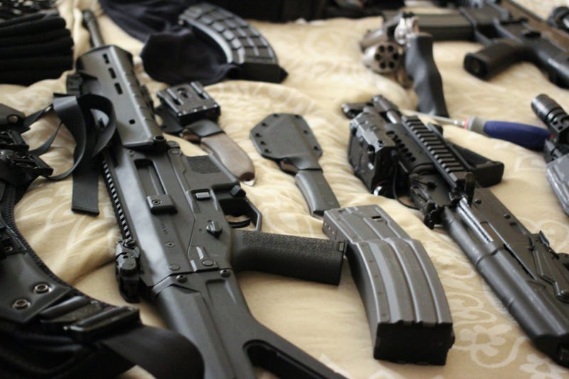 assorted guns on a bed