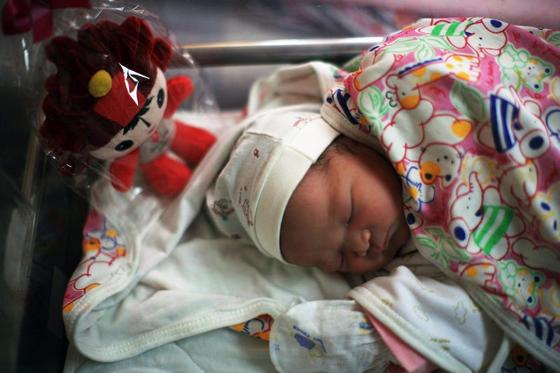 BEIJING - AUGUST 08: A Chinese baby sleeps next to a Beijing Olympic Mascot Fuwa at the Beijing Haidian maternal and child healthcare hospital after being born on August 8, 2008 in Beijing, China. There were 50 babies born at the hospital, about 60 percen
