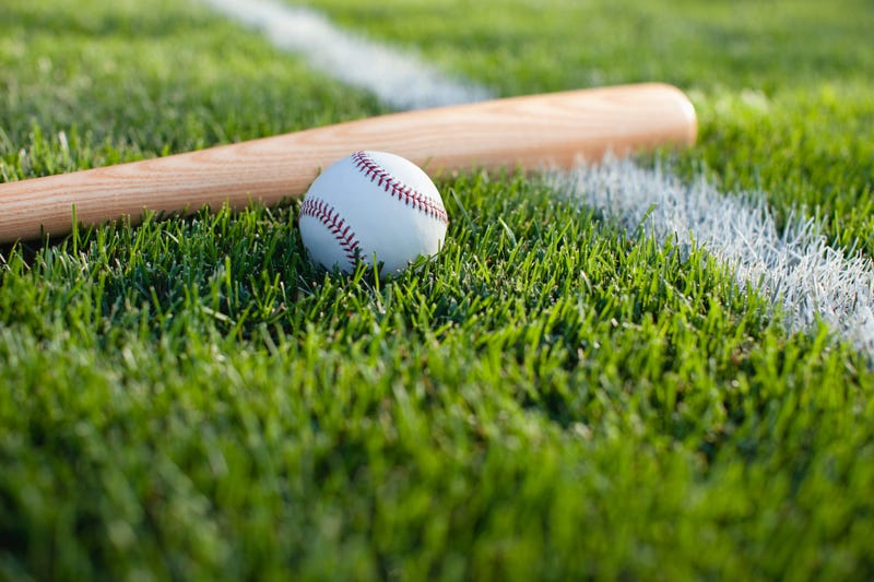Baseball and bat on grass field with white stripe