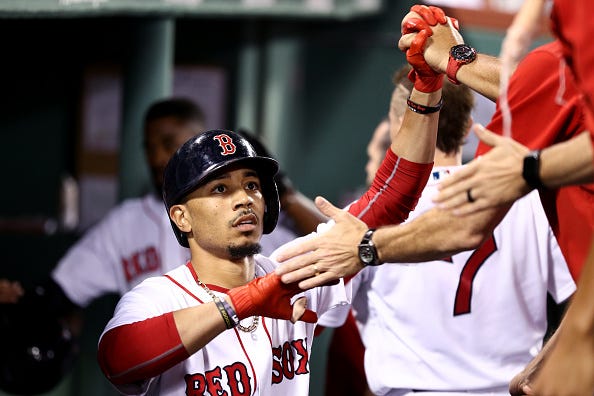 Mookie Betts celebrates with teammates in a game against the Cardinals.