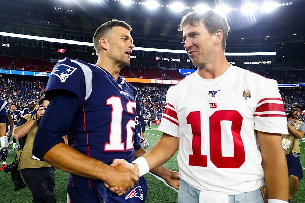 Tom Brady greets Giant quarterback Eli Manning