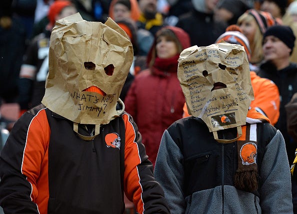 Embarrassed Browns fans hide their faces during a game.