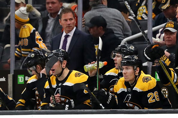 Bruins players watch from the bench during a game against the Hurricanes.