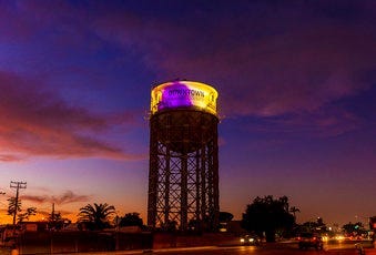 The historic 1928 Santa Ana water tower in Santa Ana, Calif., Monday, Jan. 27, 2020, is illuminated in purple and gold light in remembrance of Los Angeles Lakers legend Kobe Bryant. (Leonard Ortiz/The Orange County Register via AP)