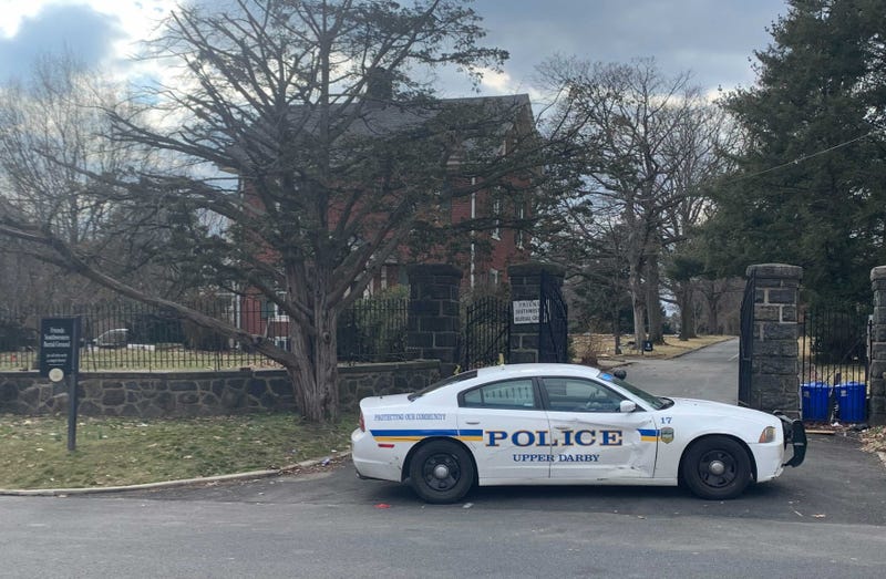 A police car sits in front of Friends Southwestern Burial Ground in Upper Darby, where two shooters opened fire during the burial of another shooting victim.