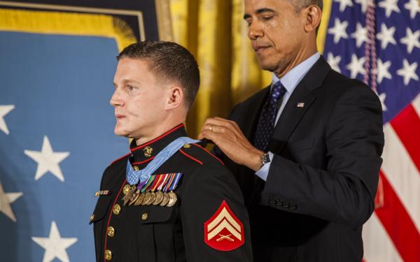 President of the United States, Barrack H. Obama places the Medal of Honor around retired U.S. Marine Corps Cpl. William Kyle Carpenter's neck, inside the East Wing of the White House, June 19, 2014.