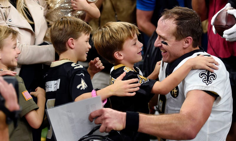 New Orleans Saints quarterback Drew Brees (9) greets his family after breaking the NFL all-time passing yards record in the first half of an NFL football game against the Washington Redskins in New Orleans, Monday, Oct. 8, 2018.