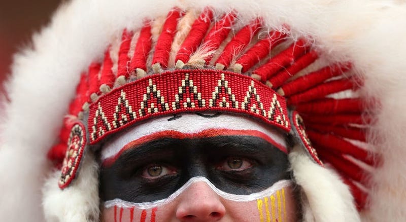 Chiefs fans wearing Native American headgear, doing Tomahawk Chop