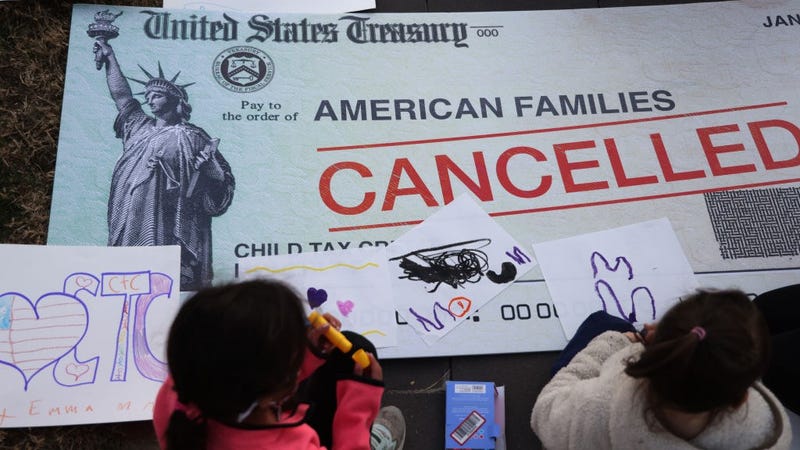 Children draw on top of a 'cancelled check' prop during a rally in front of the U.S. Capitol December 13, 2021 in Washington, DC.