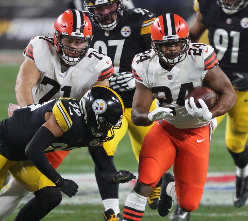 Cleveland Browns running back Nick Chubb rushes for a first down as Cleveland Browns offensive tackle Jedrick Wills blocks during the second half of an NFL wild-card playoff football game, Sunday, Jan. 10, 2021, in Pittsburgh, Pennsylvania.
