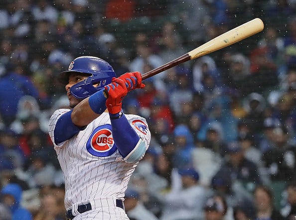Willson Contreras watches a ball he hit through the rain.