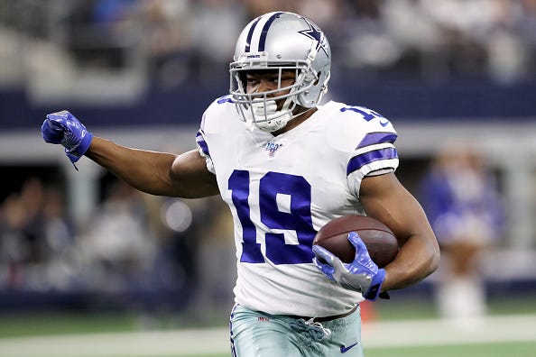 Cowboys WR Amari Cooper looks to make a move after a reception.