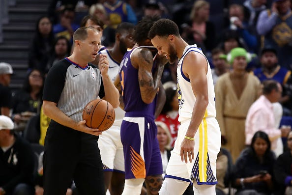 Steph Curry grimaces after breaking his left hand in a game.