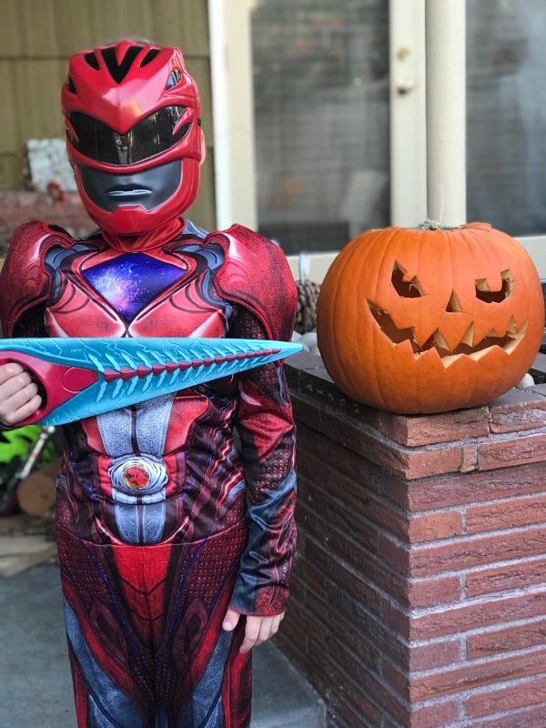 Kid in a costume, with a pumpkin