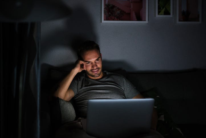 Man in dark room binge watching TV