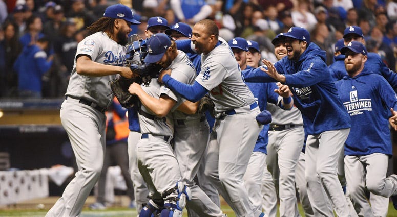 Dodgers pitcher Clayton Kershaw (22) celebrates with teammates after defeating the Milwaukee Brewers in Game 7 of the NLCS at Miller Park in Milwaukee.