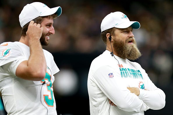 Dolphins QBs Josh Rosen (r) and Ryan Fitzpatrick watch from the sidelines.