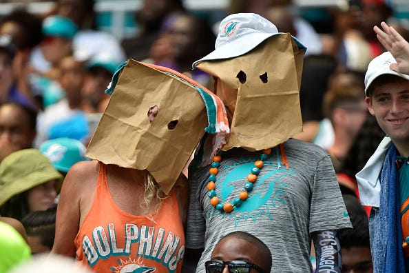 Ashamed Dolphins fans wear paper bags over their heads.