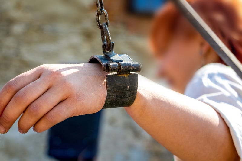 The woman is wrapped in iron chains_.