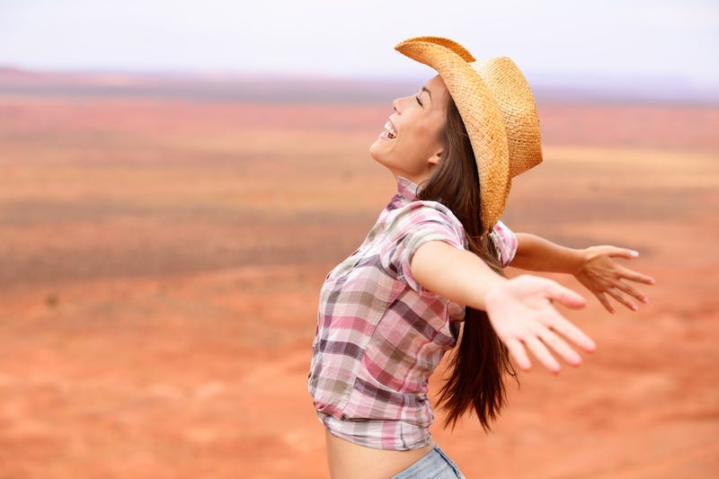 Cowgirl - woman happy and free on american prairie.