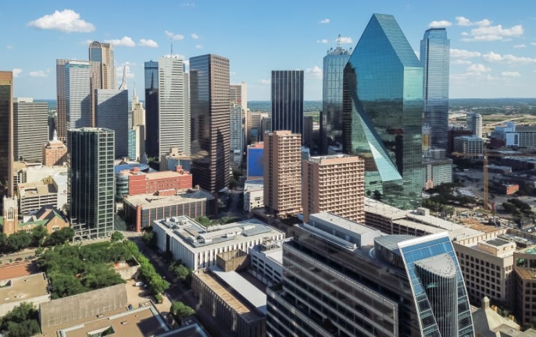 Aerial view Downtown Dallas skyscrapers under cloud blue sky. Midtown, freeway