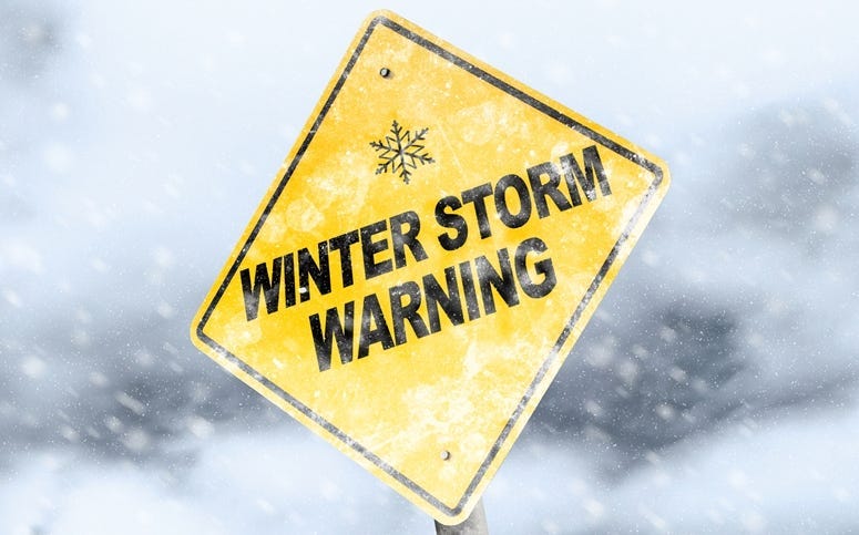 Winter Storm Warning Sign With Snowfall and Stormy Background.