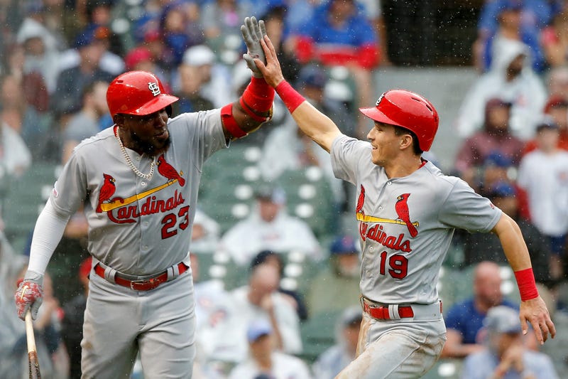 Tommy Edman celebrates scoring a run with Cardinals teammate Marcell Ozuna.