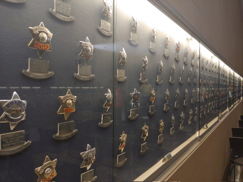A wall of Chicago police badges enshrined behind glass