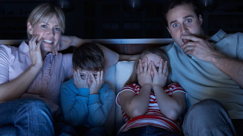 Family watching scary movie on the couch