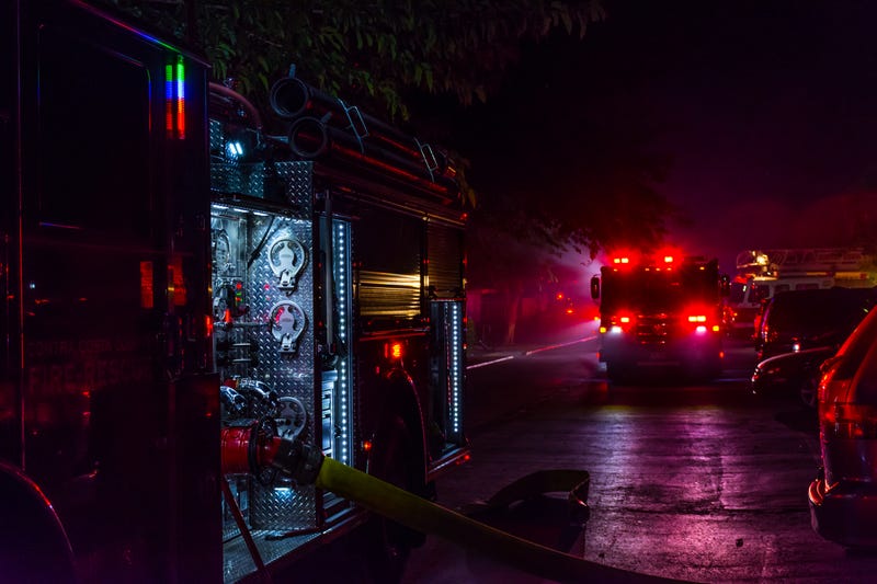 Fire trucks lighting up the scene on location at an active fire