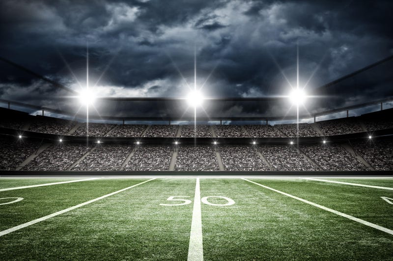 A football field under stadium lights