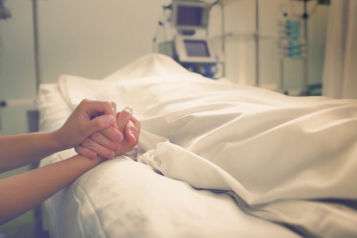 Woman mourns her husband, who died in a hospital.