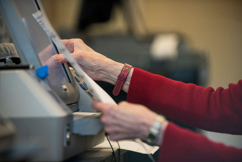 Election official Mary Wickersham enters selections into a voting machine during a public accuracy testing of Election Day voting machines, Oct. 23, 2018 in Minnesota.