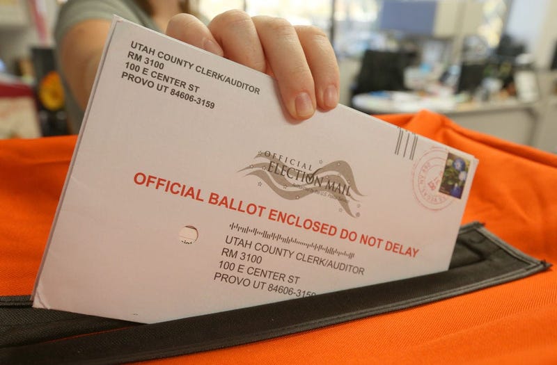 A employee at the Utah County Election office puts mail in ballots into a container to register the vote in the midterm elections on November 6, 2018 in Provo, Utah