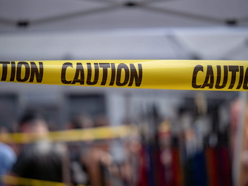 Yellow caution tape is stretched across the site of an emergency.