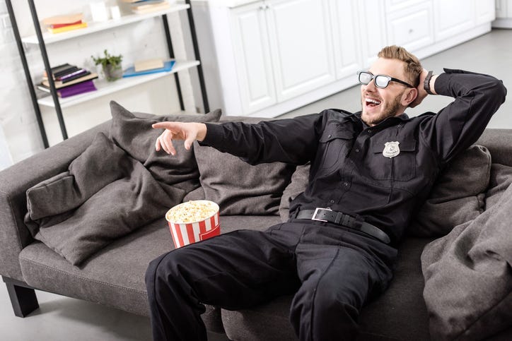 policeman in 3d glasses sitting on couch and watching movie