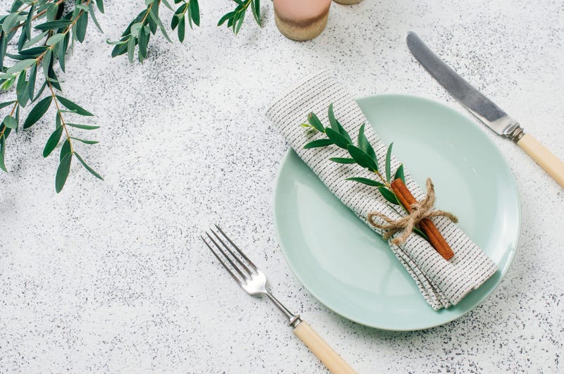Holiday elegant table setting with linen napkin, sprig and cinnamon. Top view, flat lay.