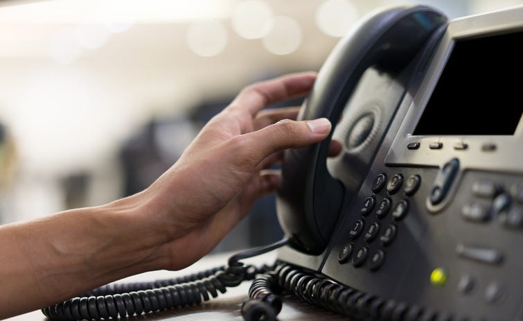 Person touching handset of telephone