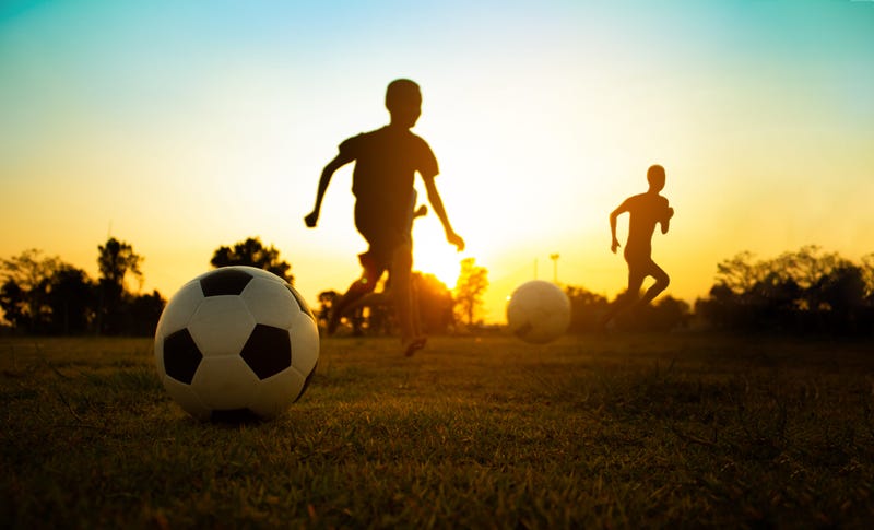 Kids playing soccer in a city park