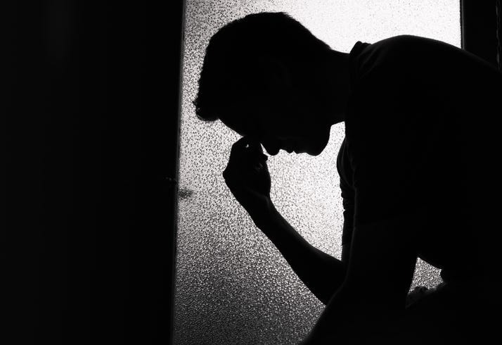 A sad person siting in a dark room