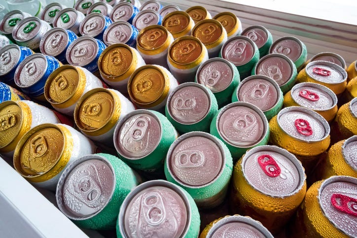 Beer cans Fresh from the fridge. Lots of aluminum cans in the ice in the open fridge. Drops of water on a cold can of drink.
