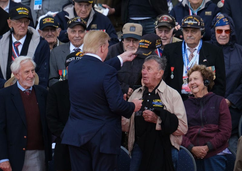 President Donald Trump tips the cap of a U.S. veteran of the Battle of Normandy as other veterans look on during the main ceremony to mark the 75th anniversary of the World War II Allied D-Day invasion of Normandy at Normandy American Cemetery in 2019.
