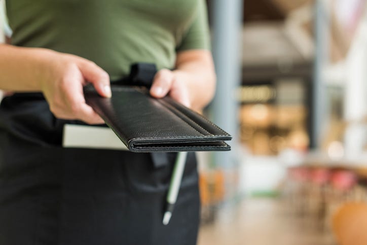 waitress offers bill at restaurant
