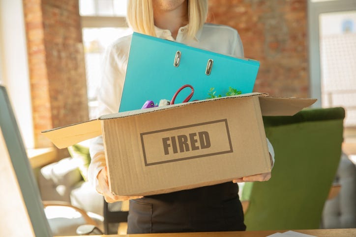 Young businesswoman fired, looks upset. Has to pack her office belongings and to leave work place for new worker. Problems in occupation, stress, unemployment, new way of life or end of career.