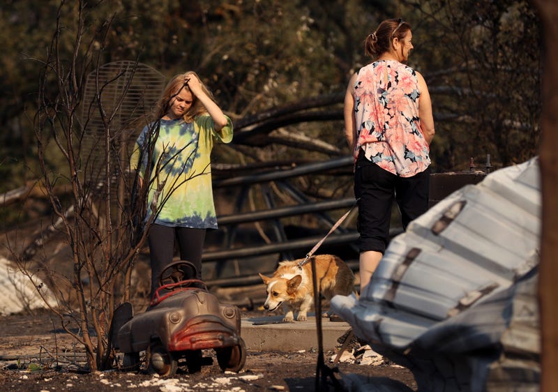 Ashley LaFranchi (L) and Stephanie LaFranchi (R) walk through a family home that was destroyed by the Kincade Fire on October 28, 2019 in Calistoga.
