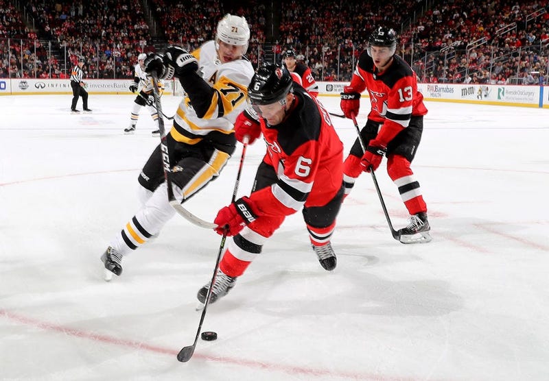 Andy Greene #6 of the New Jersey Devils takes the puck as Evgeni Malkin #71 of the Pittsburgh Penguins defends