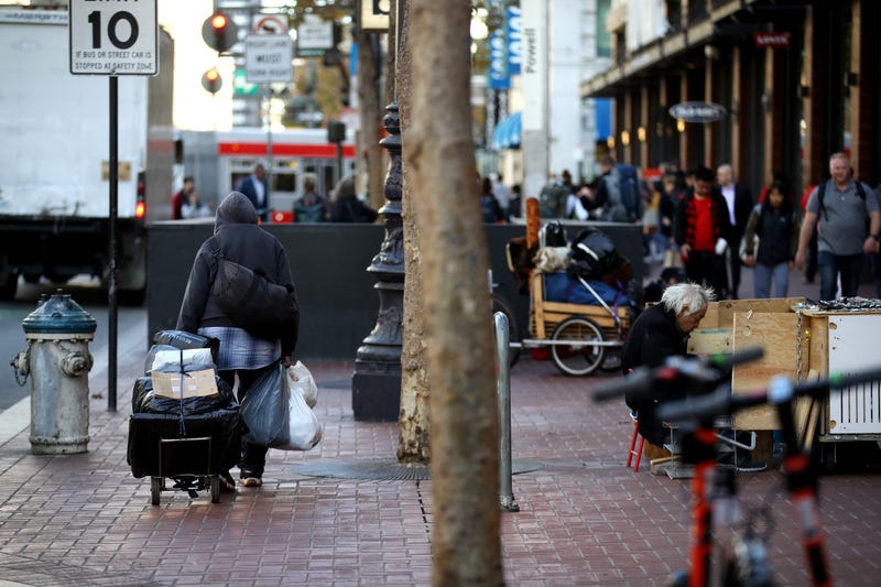A homeless man spulls a cart with his belongings on November 25, 2019 in San Francisco.