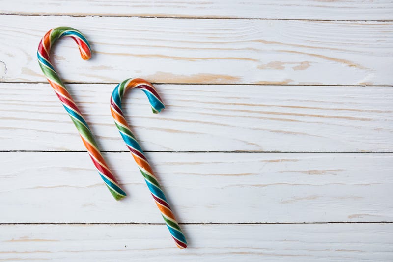 Colorful festive Lollipops on white wooden background selective focus top view