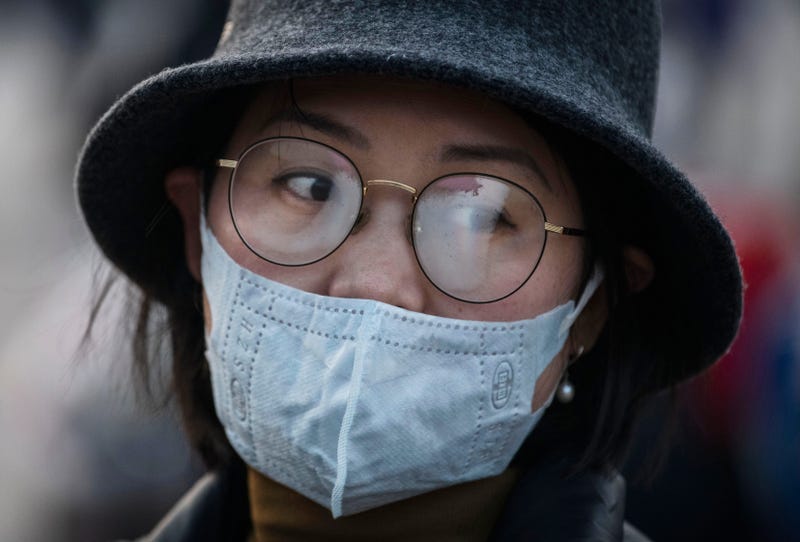 A Chinese woman's glasses fog up while wearing a protective mask at Beijing Station before she boarded a train before the annual Spring Festival on January 22, 2020 in Beijing, China.