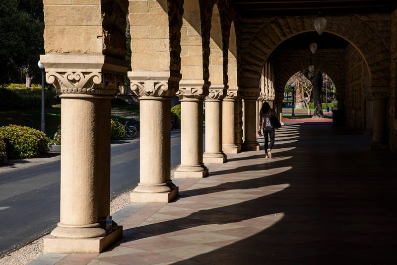 A person walks past archways during a quiet morning at Stanford University on March 9, 2020.
